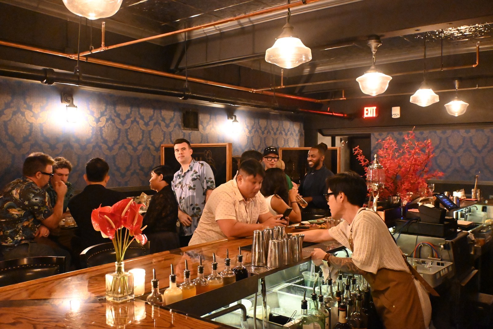 A bartender and guests at the counter
