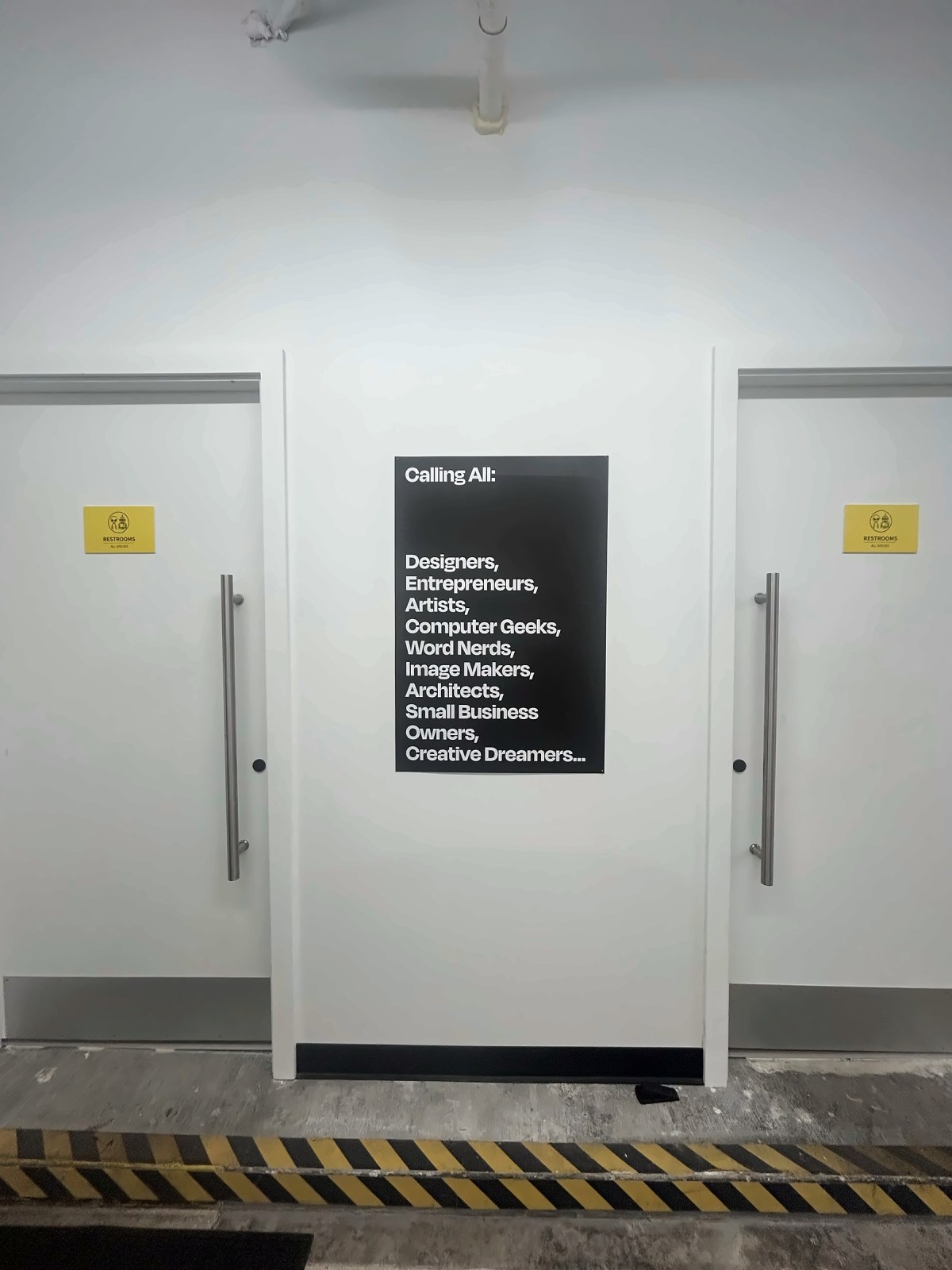 Two restroom doors under a "Calling All" poster
