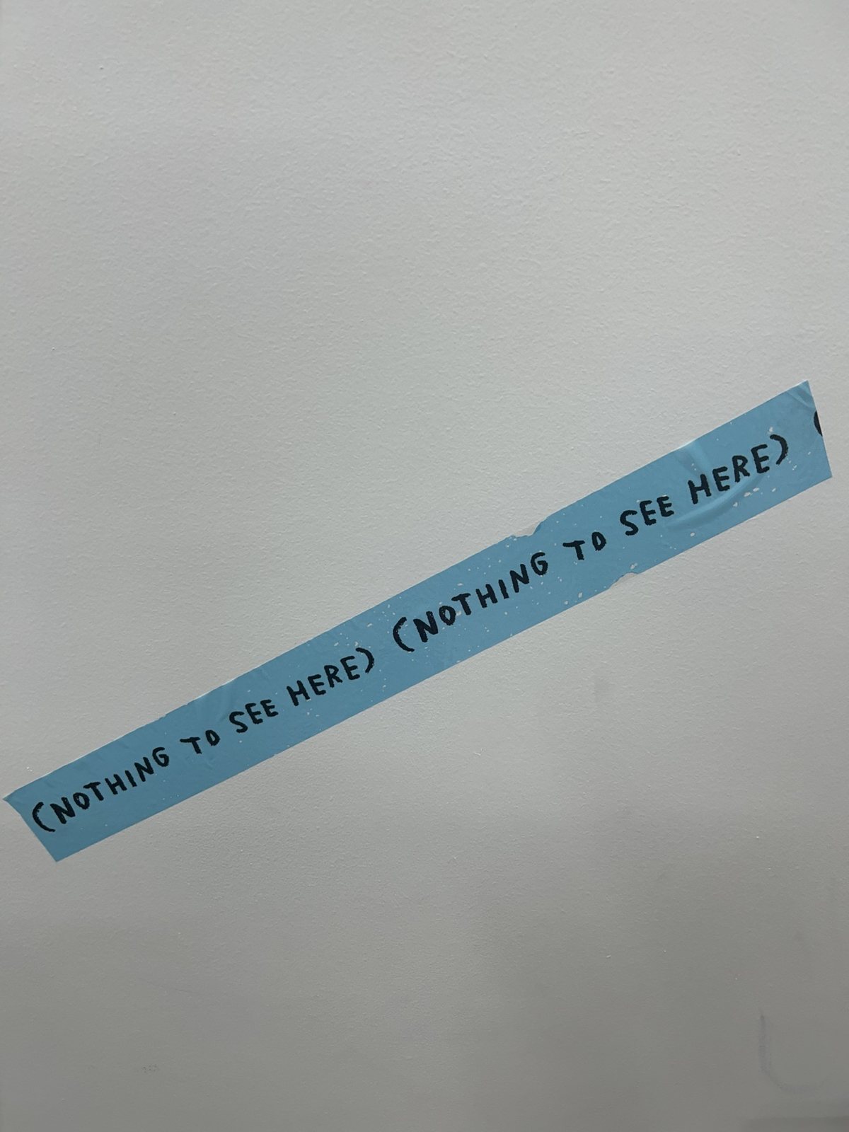 Blue painter's tape lettered "(NOTHING TO SEE HERE)"