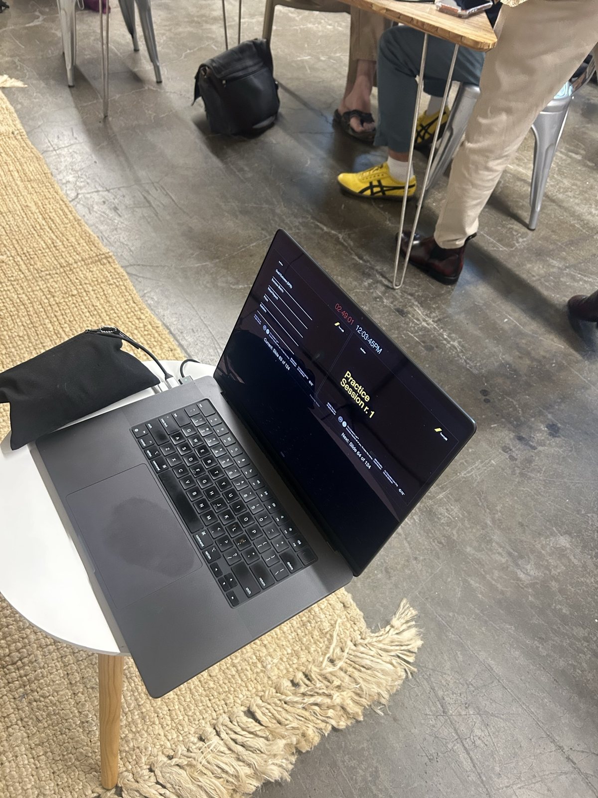 A laptop on a small round table, a worksheet below