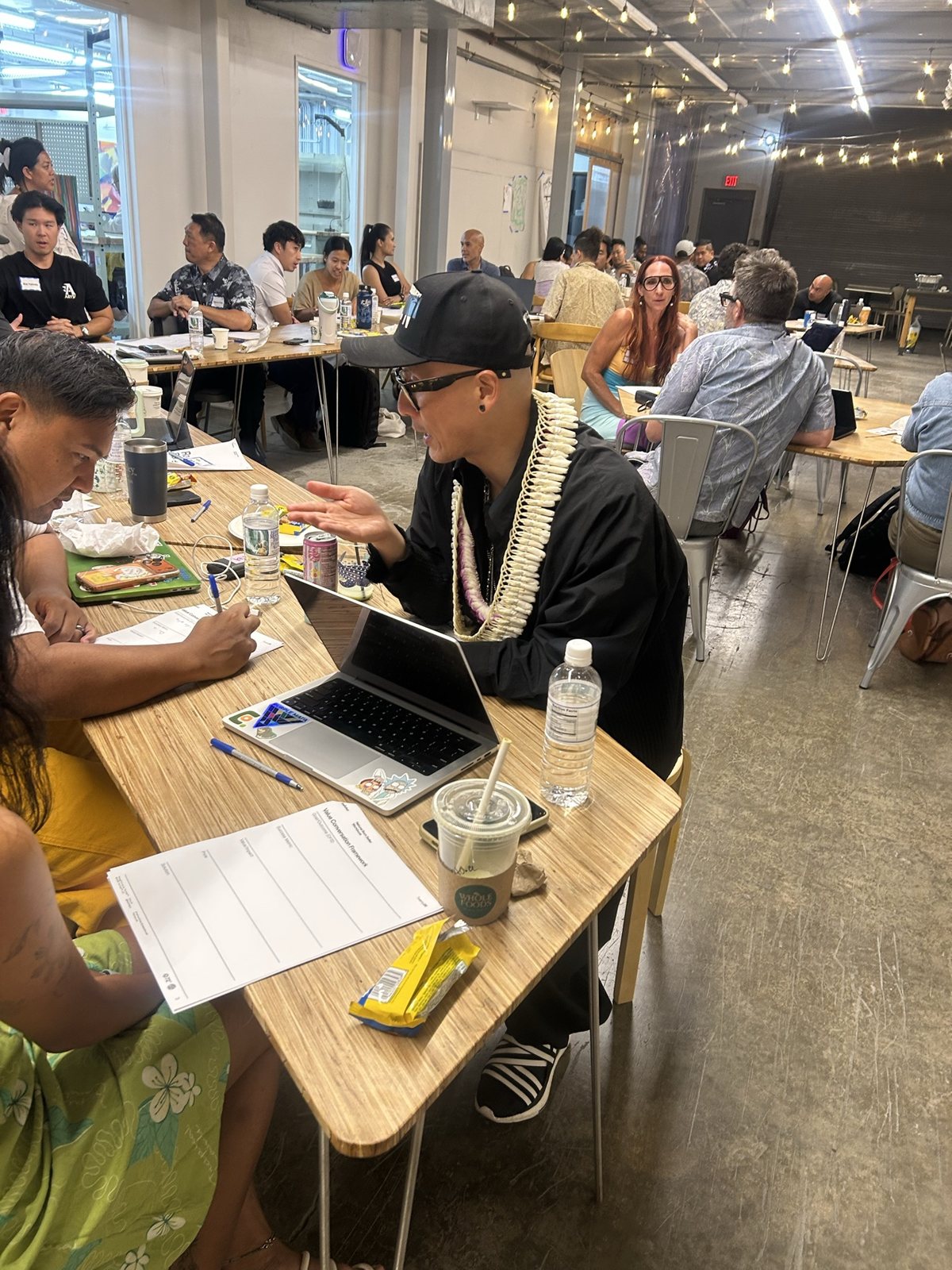 Attendees filling in worksheets, a laptop open between them