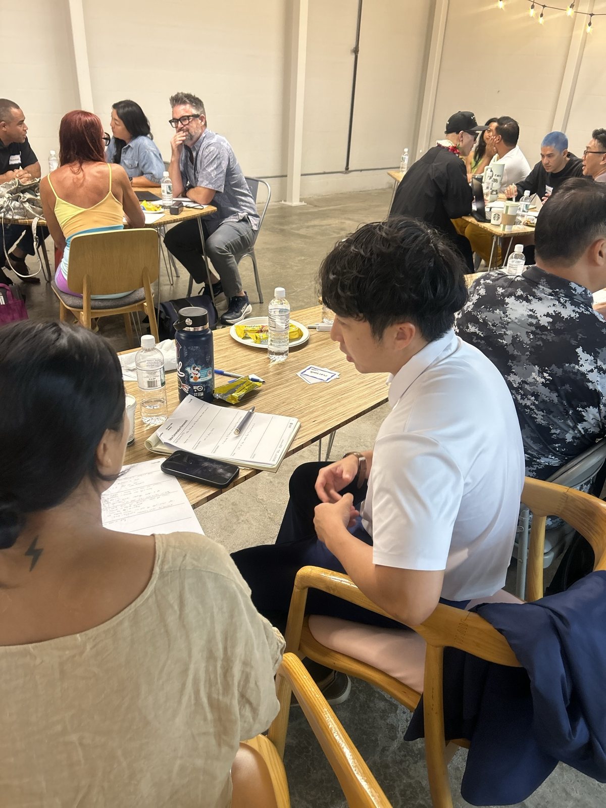 Two attendees at a table, one writing