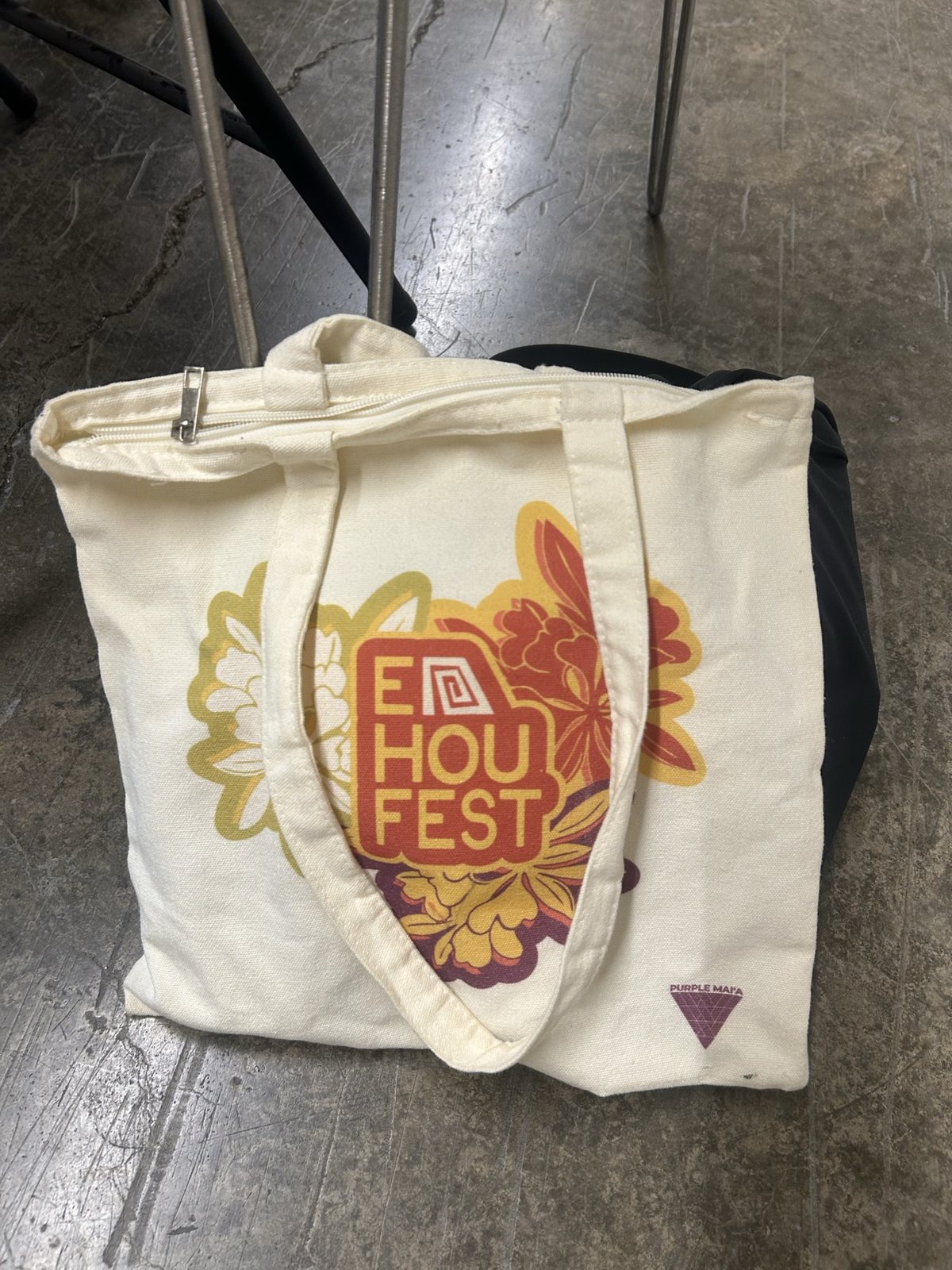 A Hou Fest tote bag on the concrete floor