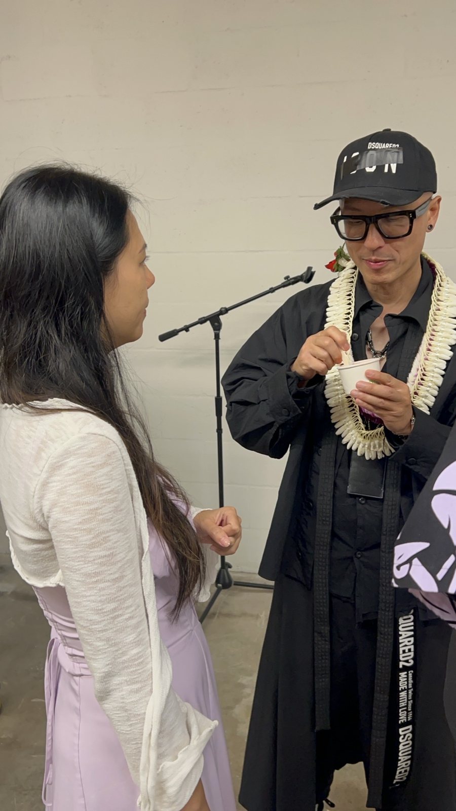 A woman and Chris Do talking beside a microphone stand