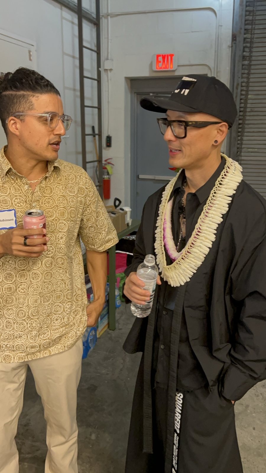 Chris Do talking with an attendee by a roll-up door