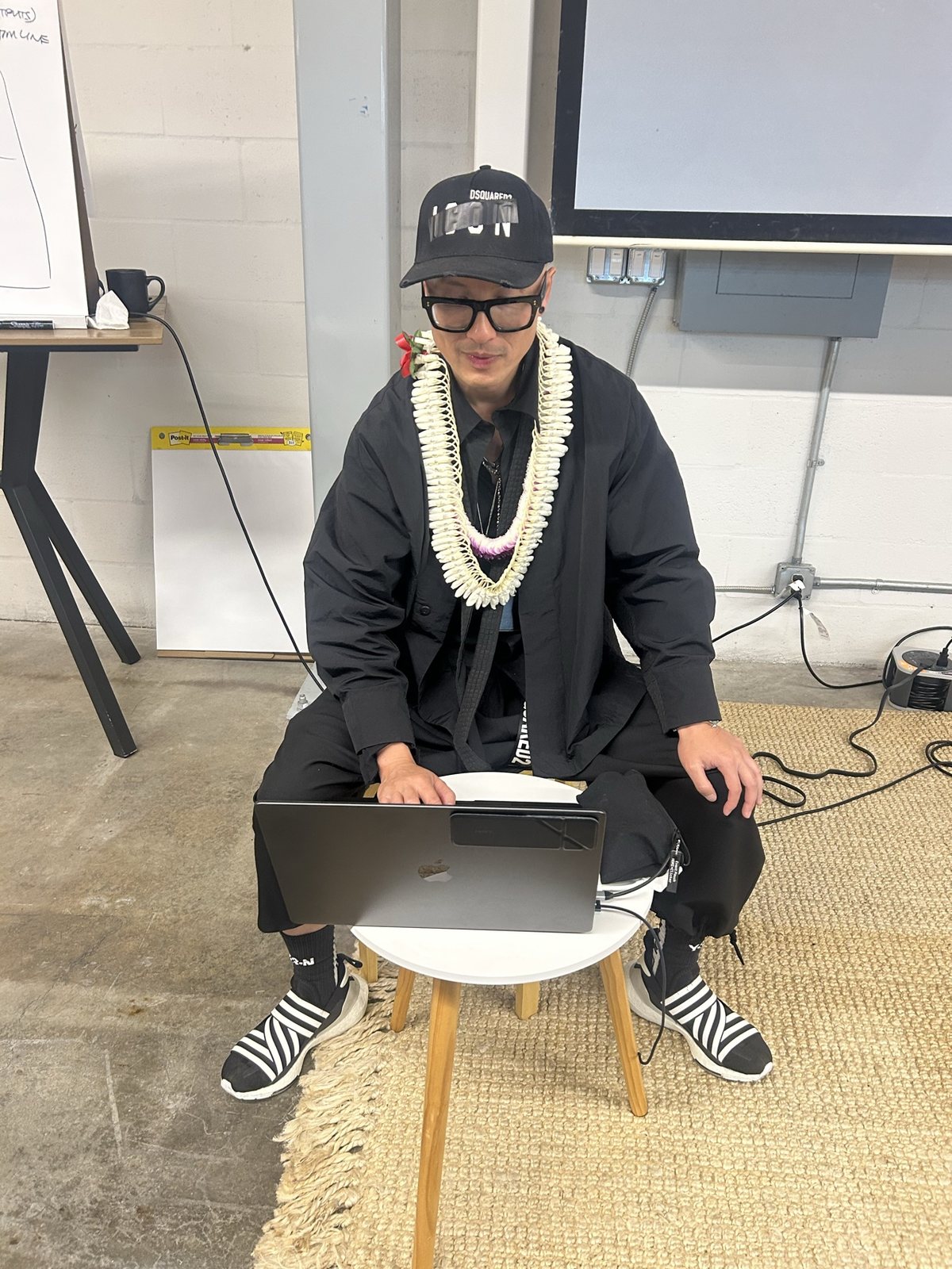 Chris Do on a stool with a laptop