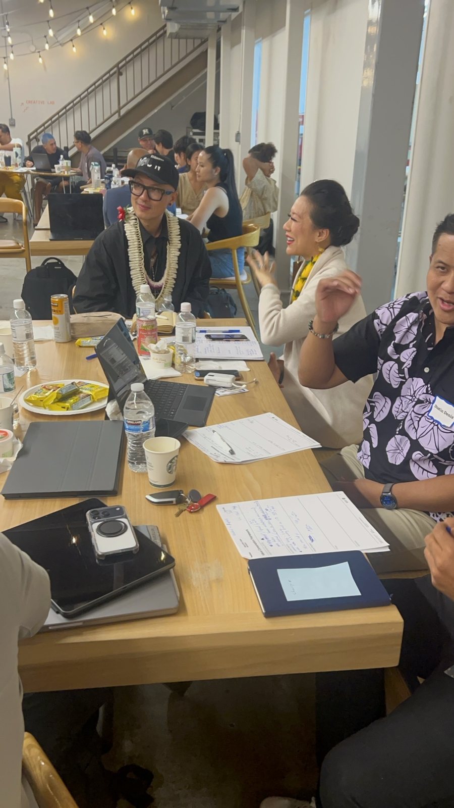 Attendees at a long table with open notebooks
