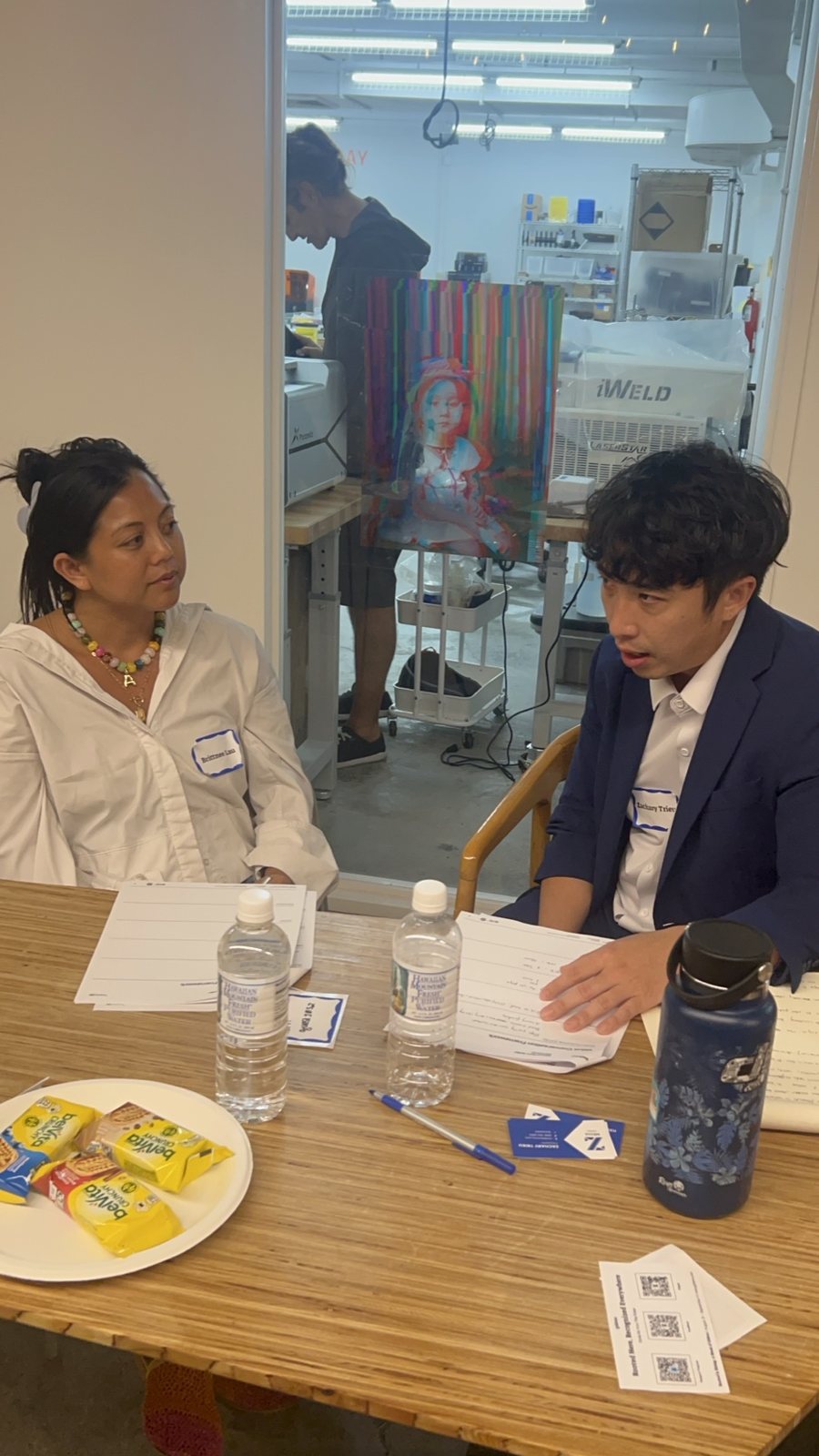 Two attendees at a table with a snack plate