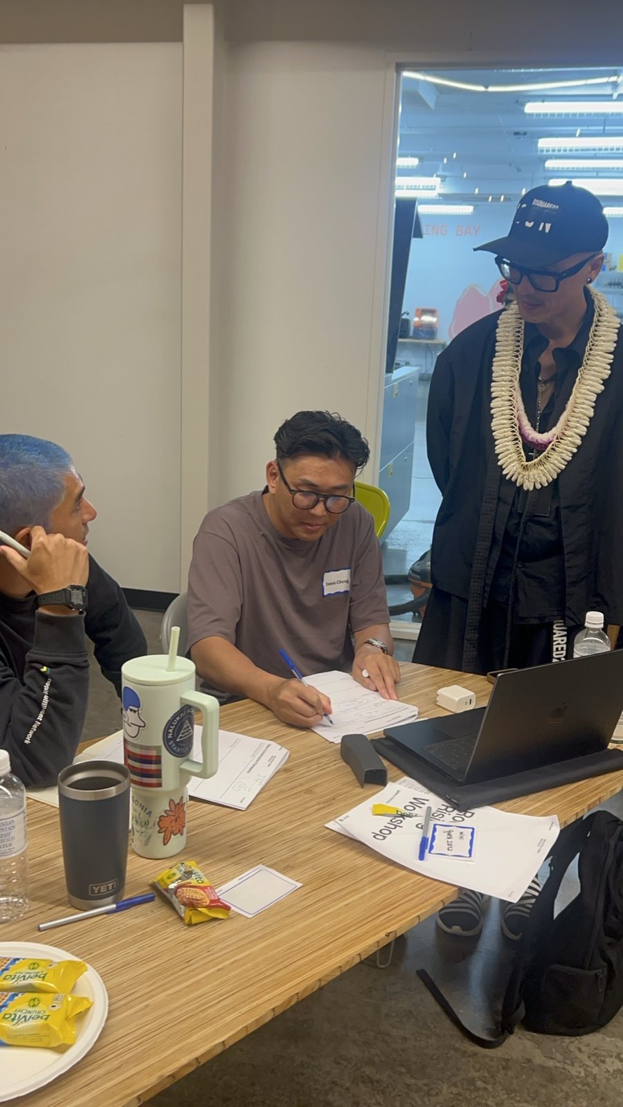 Chris Do talking with attendees at a table