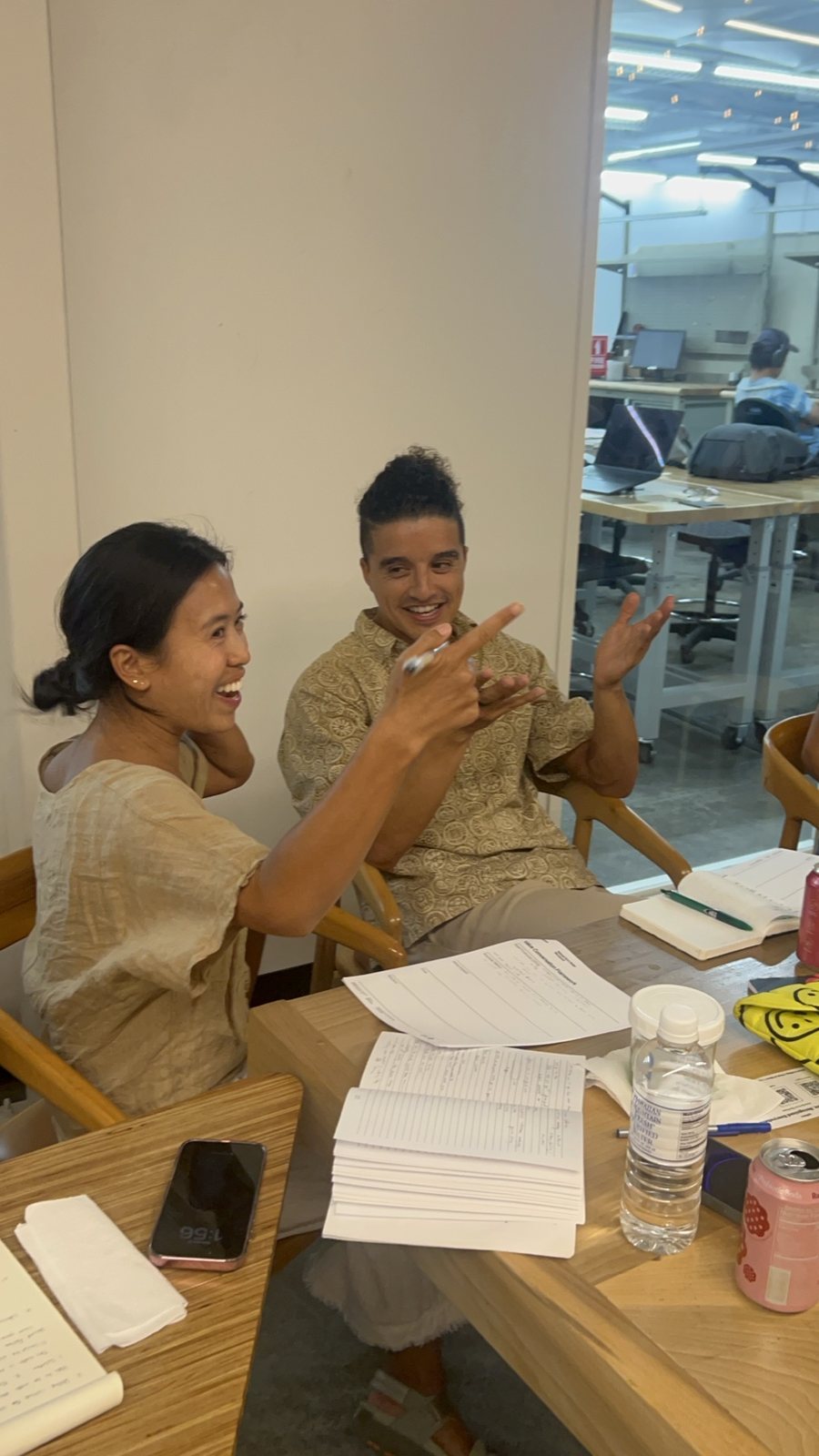 Two attendees laughing over a table of worksheets