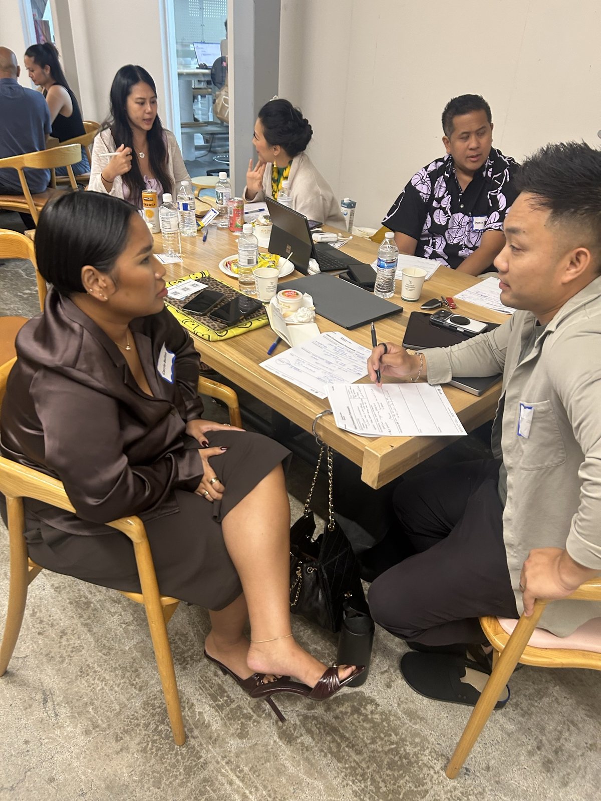 Two attendees at a table, one writing