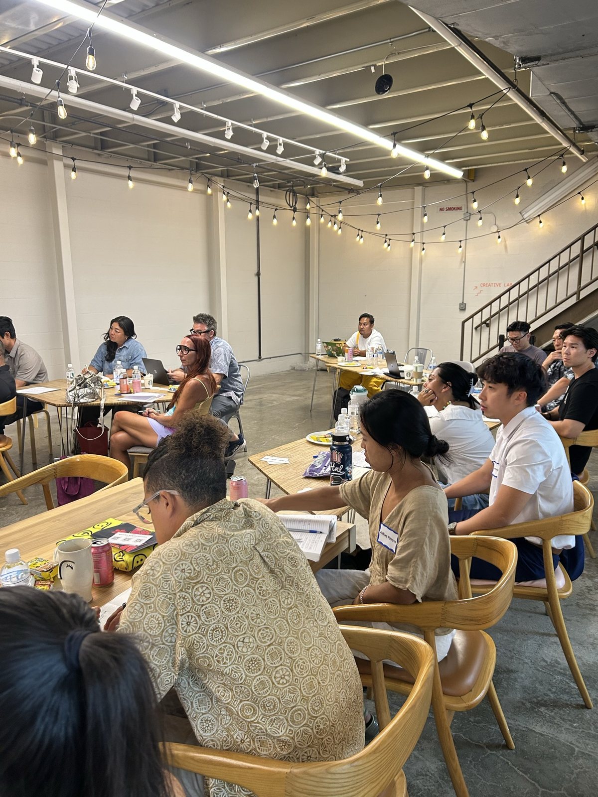 Attendees at wooden tables in rows