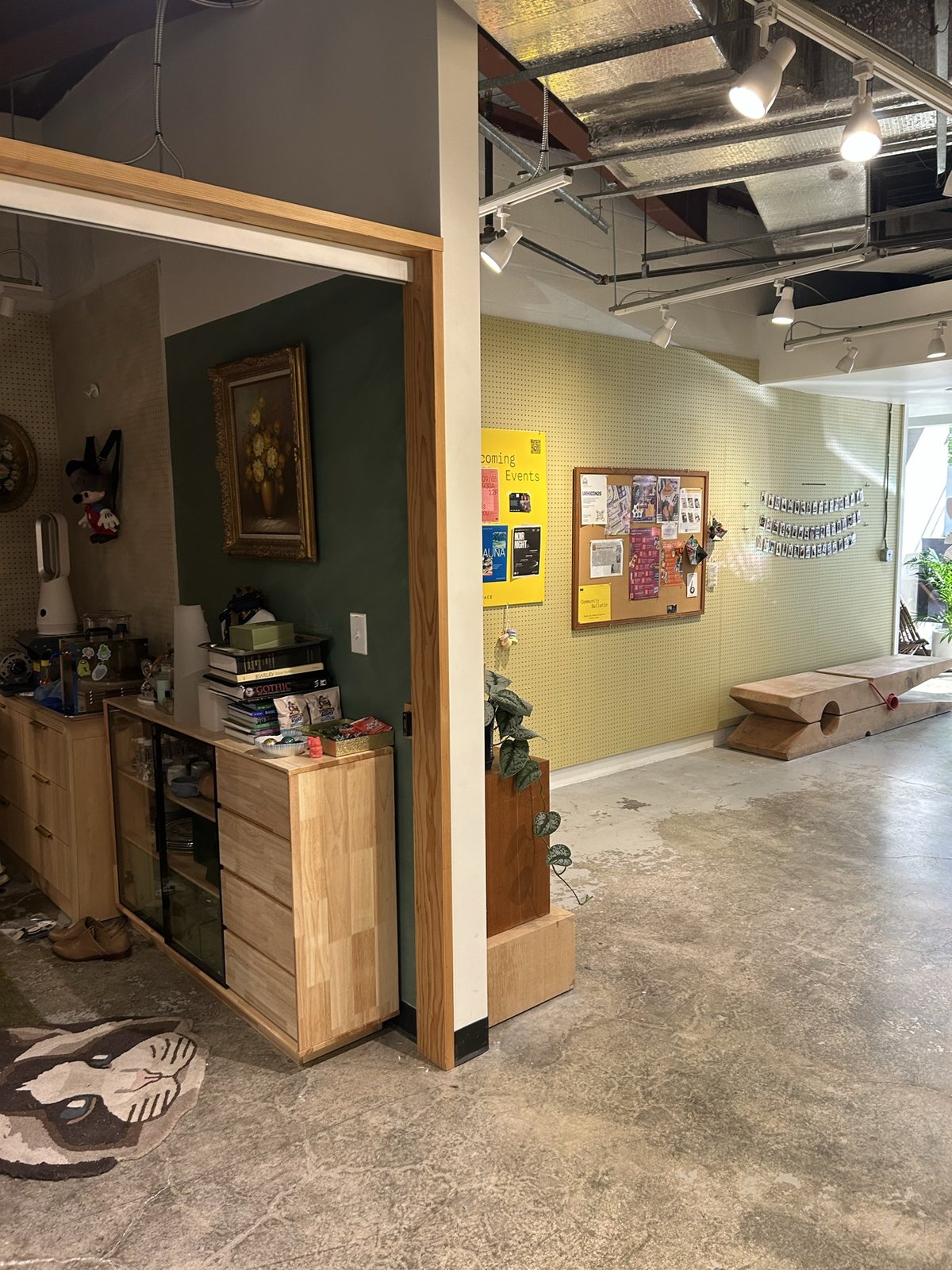A room with a framed painting and a drawer unit