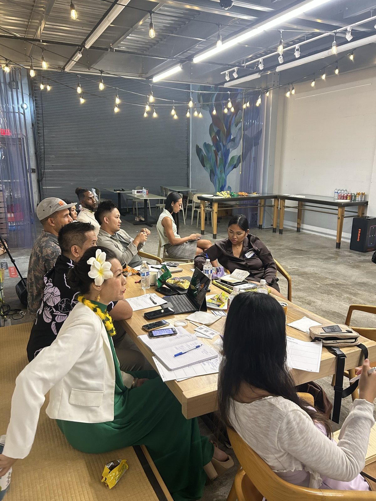 Attendees at a table under string lights