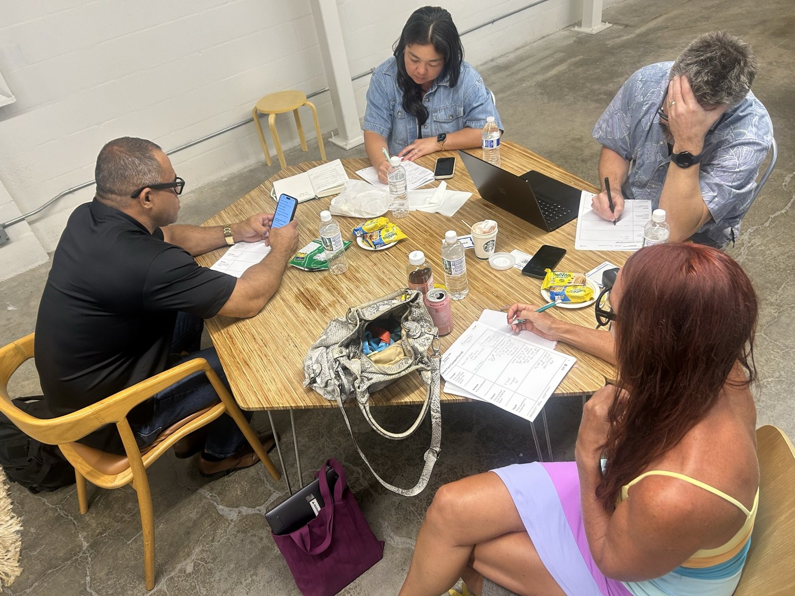 Four people around a five-sided table