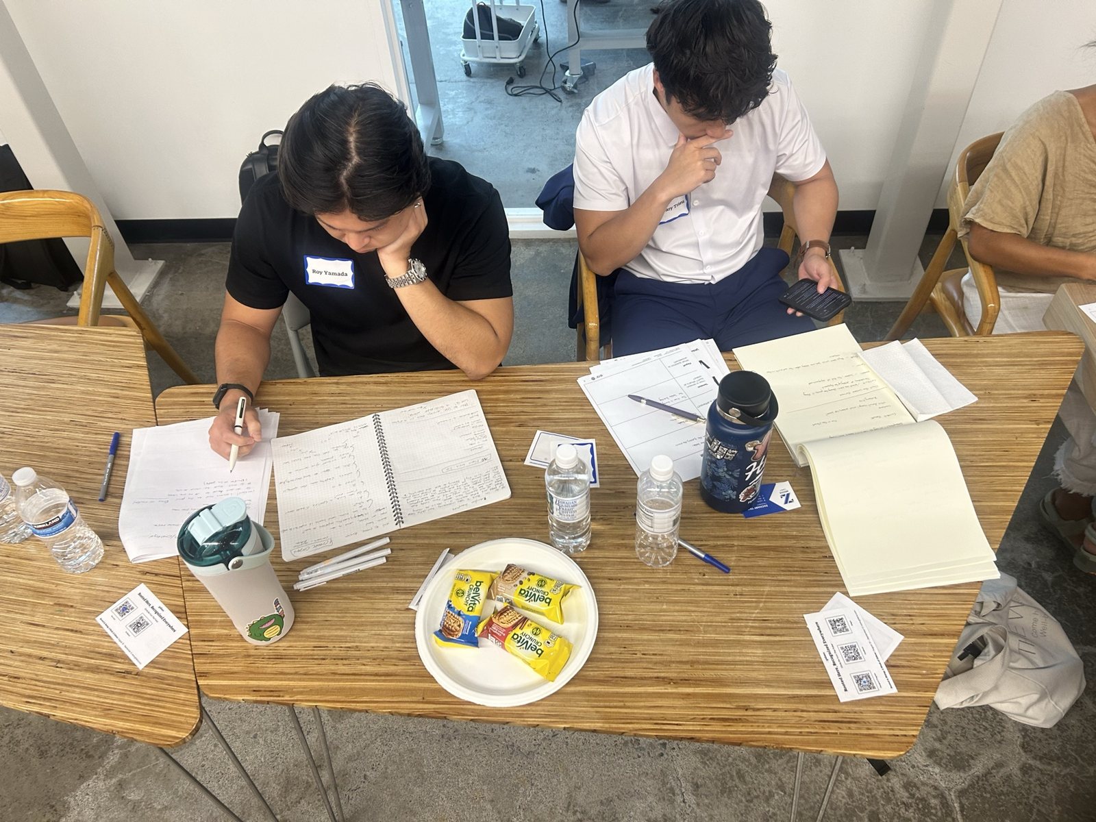 Two young men writing at a table