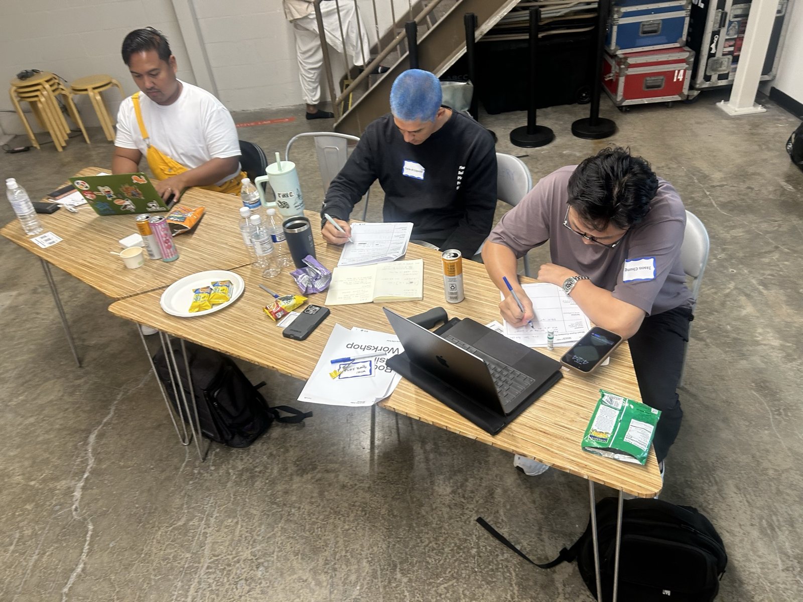 Three attendees at a table with laptops