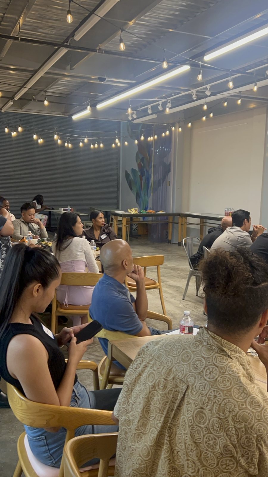 Attendees at tables, a man in an aloha shirt in the foreground