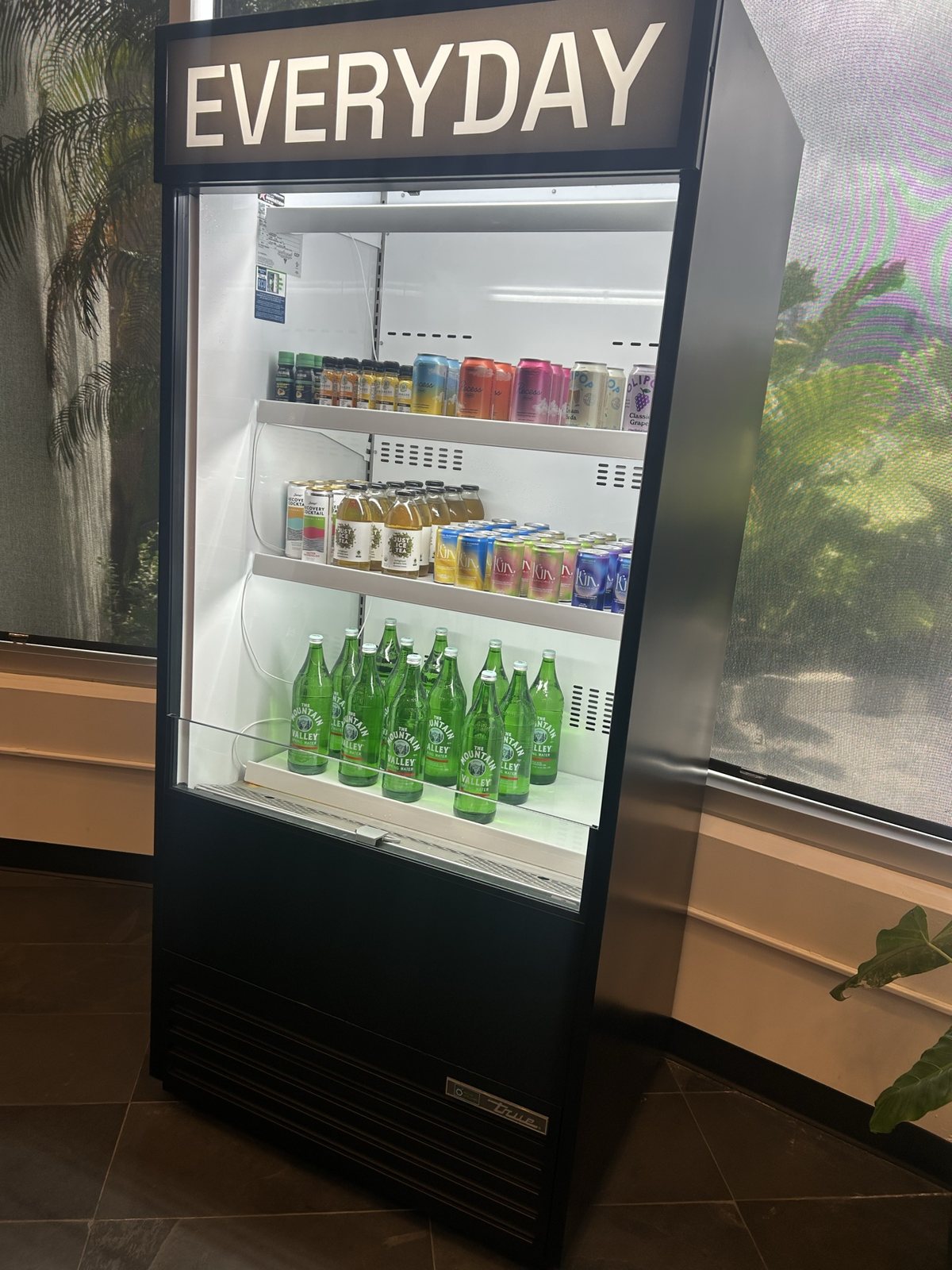 A fridge of drinks beside the Everyday sign