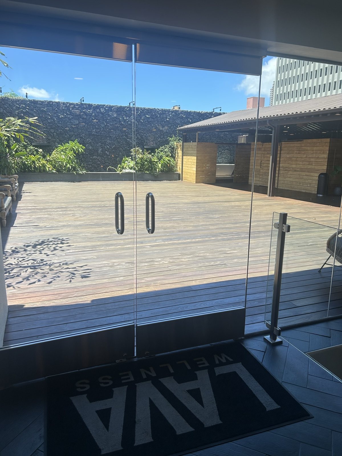 Glass doors onto the rooftop deck, a Lava Wellness mat