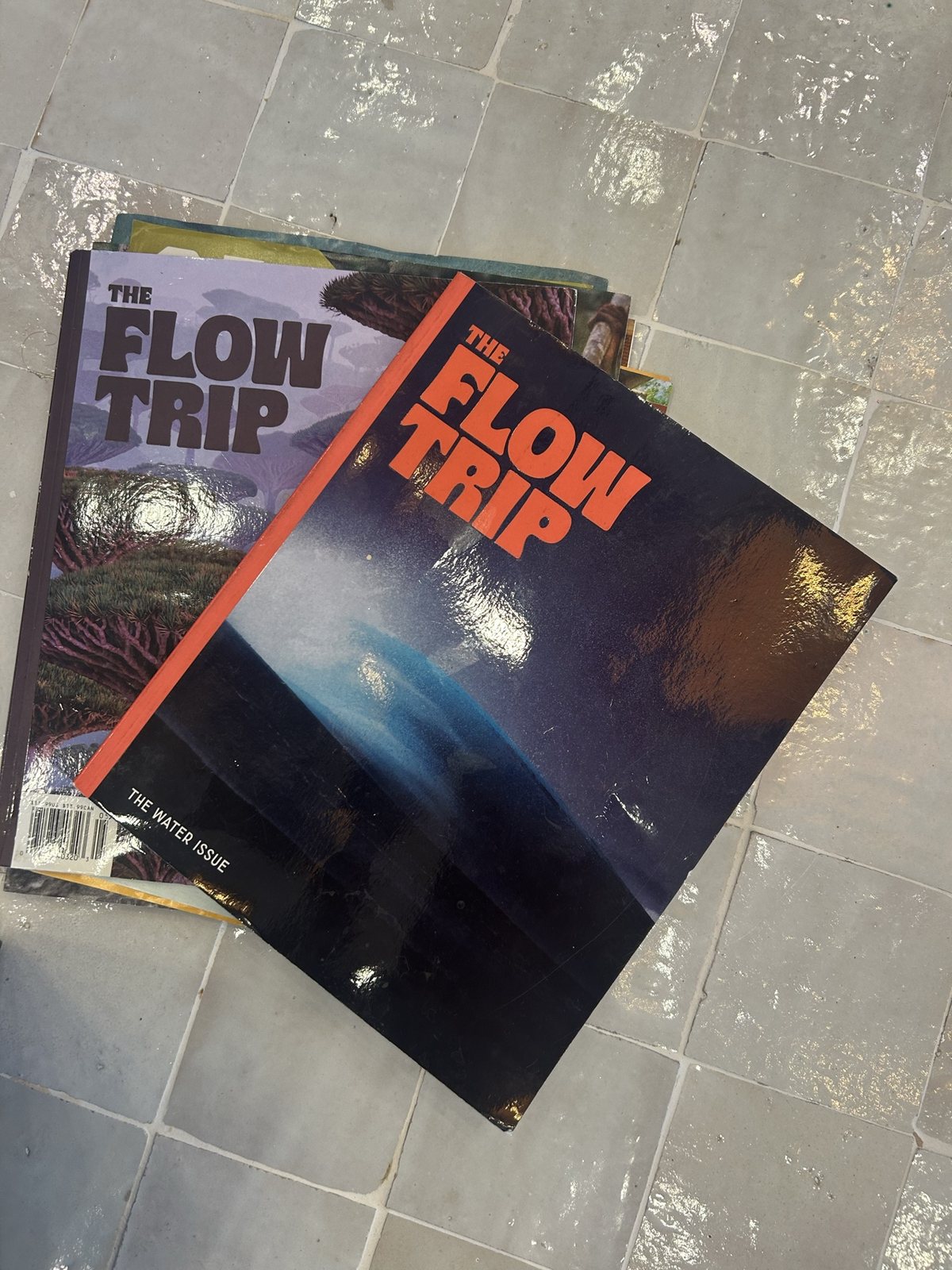 Flow Trip magazines on a tile table