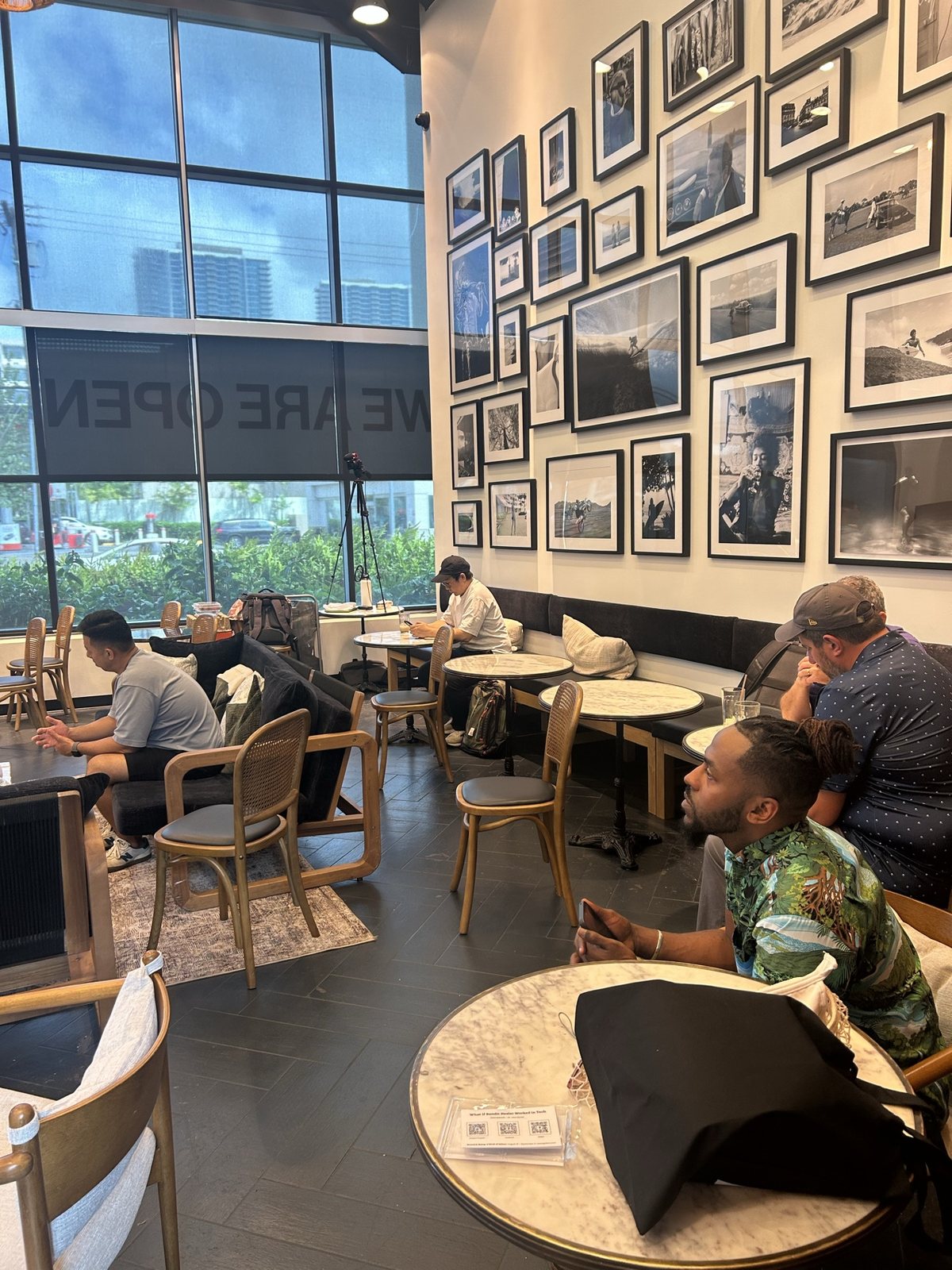 The cafe with floor-to-ceiling windows and a group in the lounge