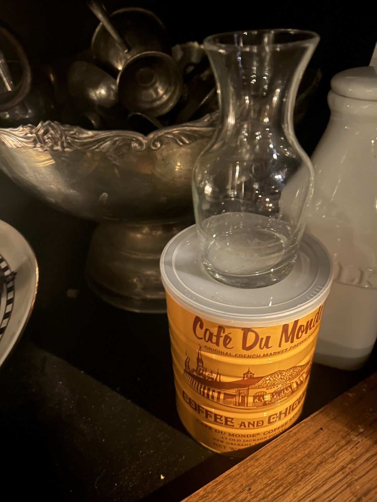 A Café Du Monde can on a dark shelf