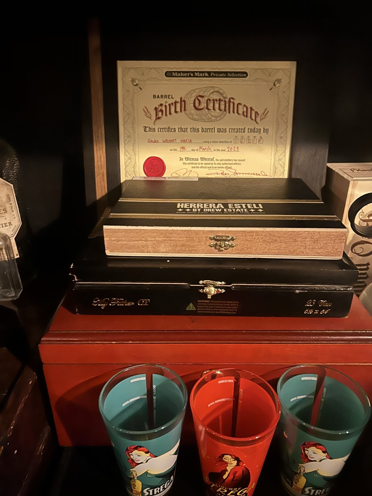 A birth certificate and cigar box among the glasses