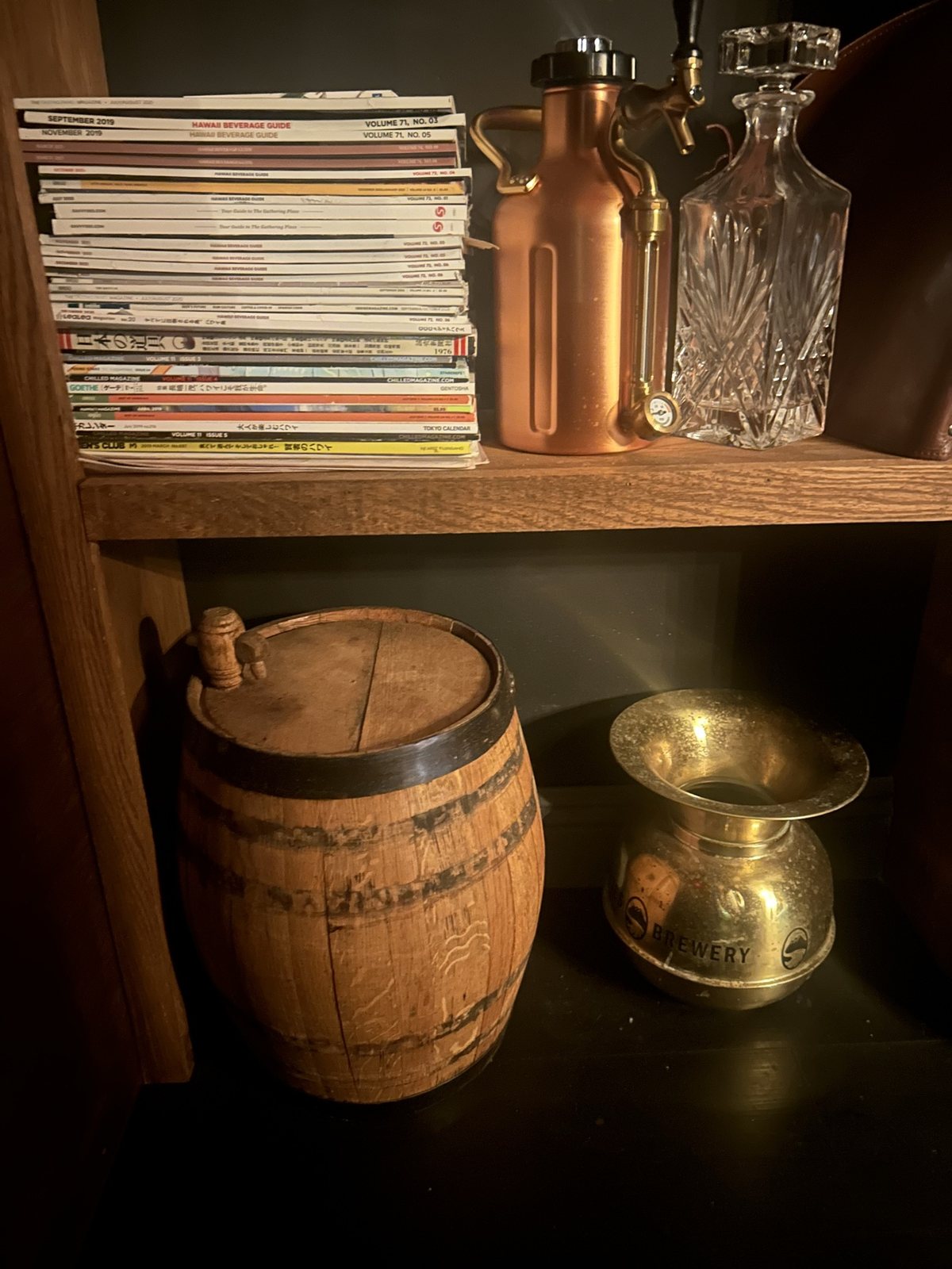 A wooden barrel and brass pieces on a shelf