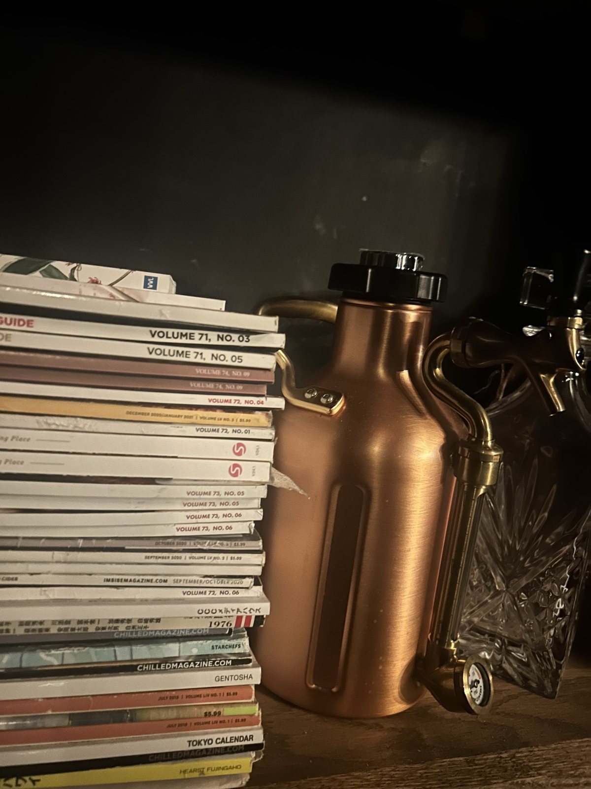 Magazines and a copper growler on a shelf