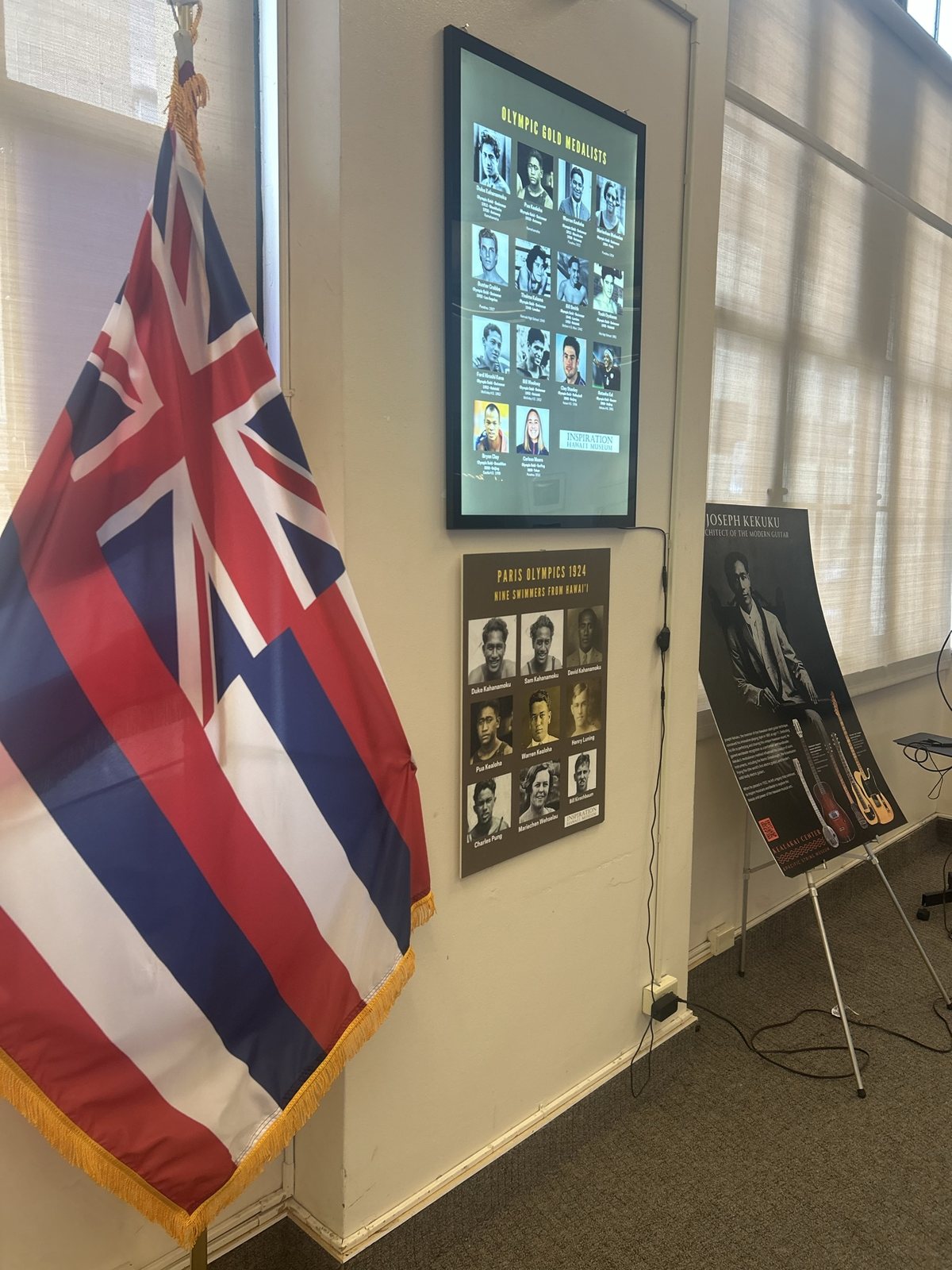 The Hawaiian state flag beside exhibit panels