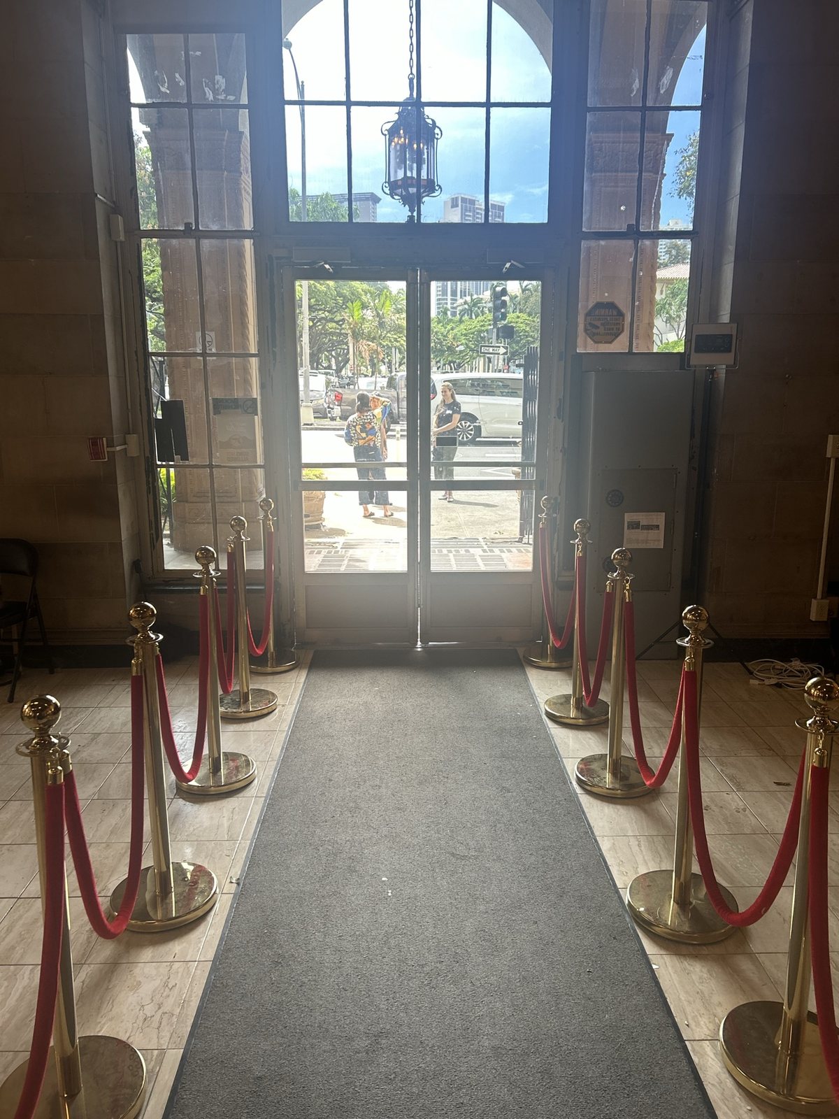 The entrance hall with red ropes and glass doors