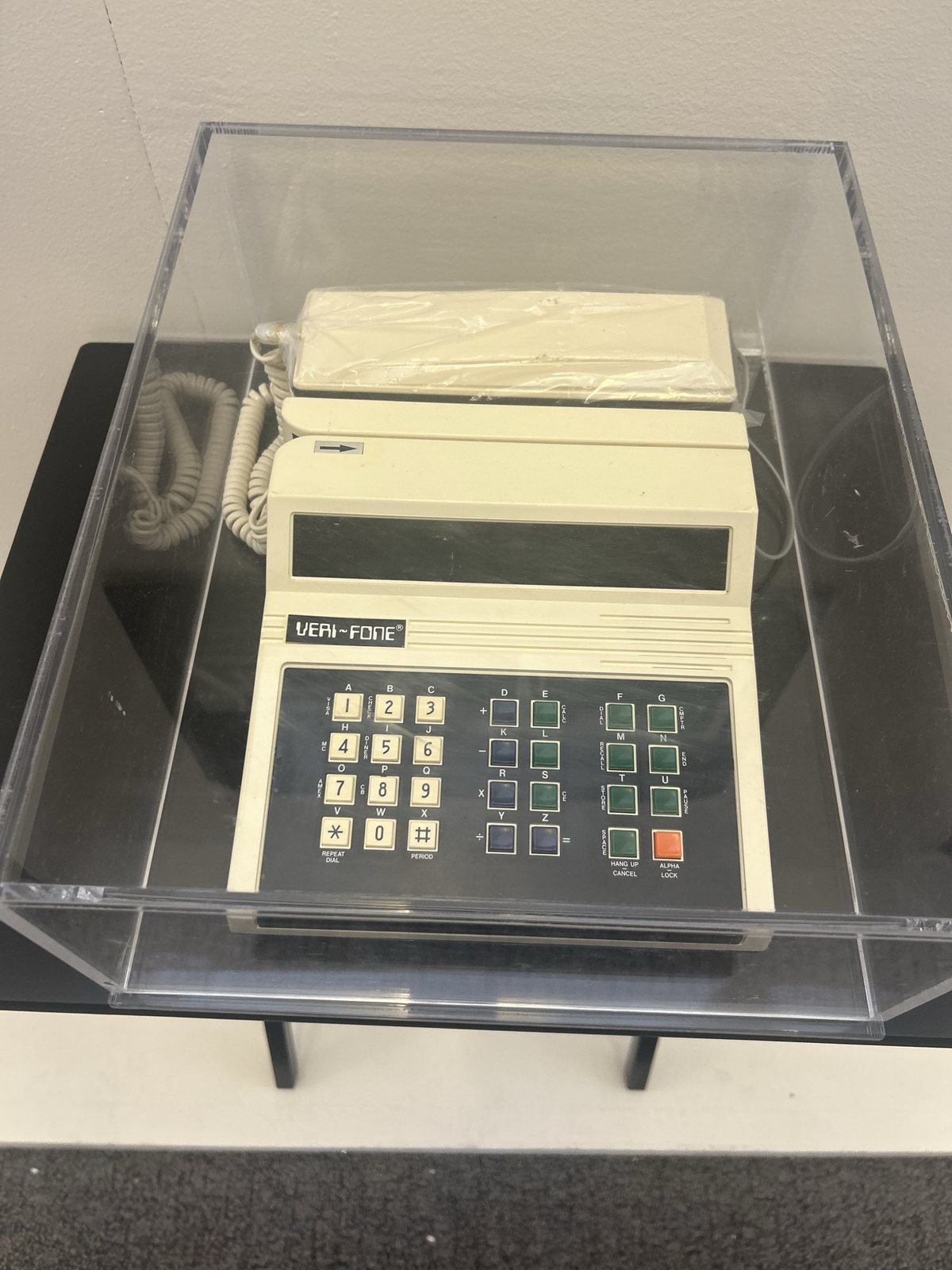 A vintage Veri-Fone credit card terminal in a case